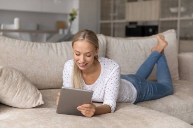 Dijital tablet kullanan mutlu genç kadın.