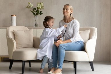 Mutlu şirin küçük çocuk annesiyle doktorculuk oynuyor..