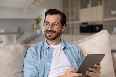 Rüya gibi mutlu genç adam dijital tablet kullanıyor..