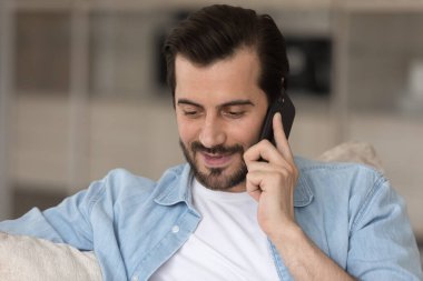 Telefon görüşmesine katılan gülümseyen genç adam..