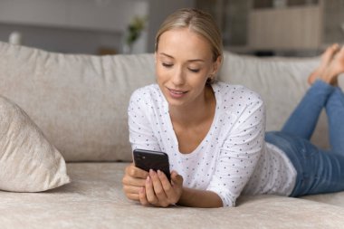 Rahat, huzurlu, çekici bir kadın cep telefonu kullanıyor..