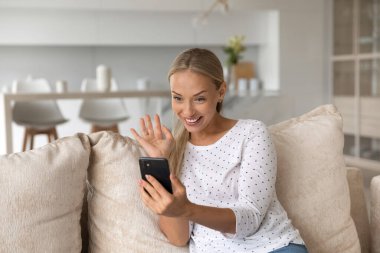 Cep telefonundan görüntülü arama yapan mutlu, güzel genç bir kadın..