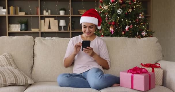 Felice donna indiana godere di regali di Natale messaggio di testo al telefono — Video Stock