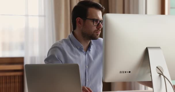Focused man employee using desktop laptop computers in office work — Stock Video