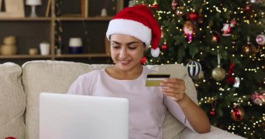 Mutlu yillik kadinlar dizüstü bilgisayar kartıyla Xmas hediyeleri alir.