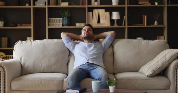 Sereno relaxado millennial cara descansar no sofá com sorriso despreocupado — Vídeo de Stock