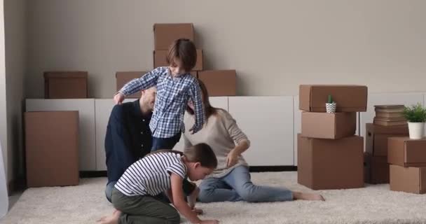 Gelukkige familie spelen, vieren verhuizen naar nieuwe woning. — Stockvideo