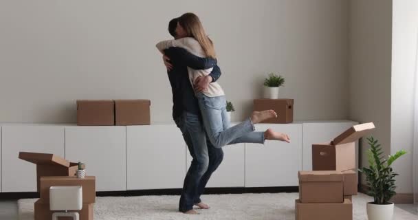 Feliz joven pareja celebrando mudarse a un nuevo apartamento. — Vídeo de stock