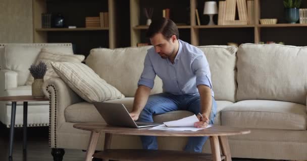 Mannelijke ondernemer betaalt belasting online met behulp van laptop op kantoor — Stockvideo