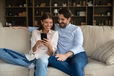 Gülümseyen genç çift cep telefonu uygulamaları kullanıyor..
