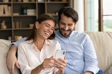 Evde cep telefonu kullanan mutlu bir aile çifti..