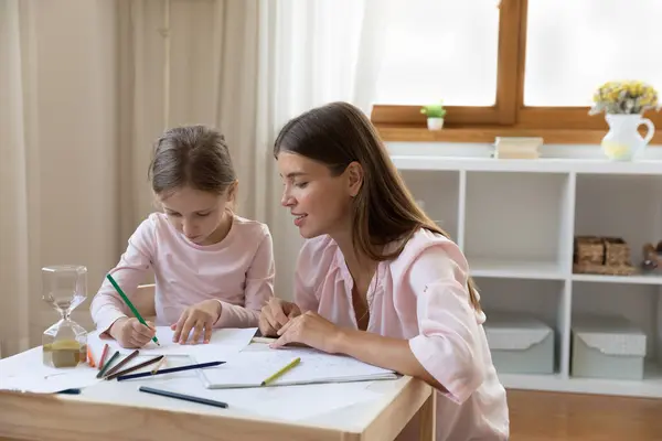 Щаслива молода мати навчає малювати маленьких дітей . — стокове фото