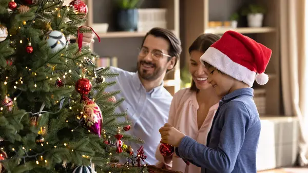 Šťastná rodina zdobení vánoční stromeček doma. — Stock fotografie