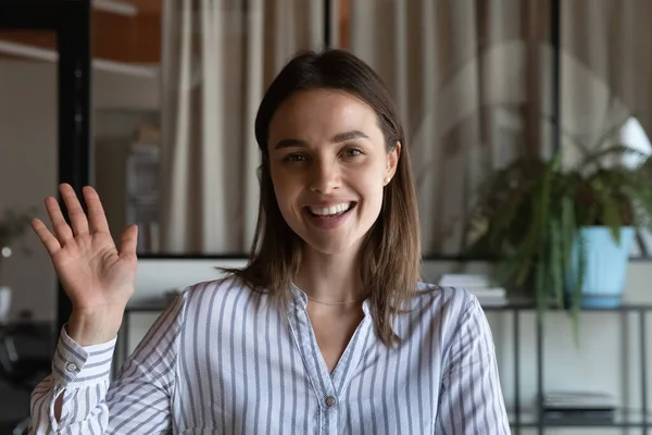 Screen portrait of smiling female presenter wave hand to camera — Stock Photo, Image