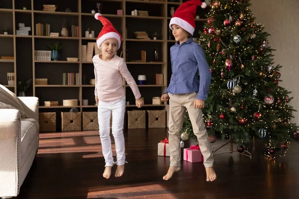 Mutlu küçük çocuklar Noel ağacının yanında dans ediyor. — Stok fotoğraf
