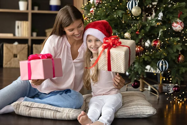 Familia feliz sosteniendo cajas de regalo, sentado cerca del árbol de Navidad. — Foto de Stock