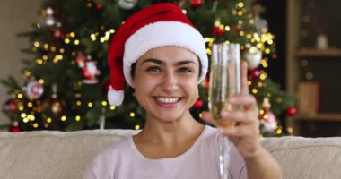 Xmas şapkalı gülen Hintli kadın elinde şampanya bardağıyla
