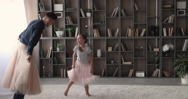 Счастливый молодой отец и маленькая дочь в юбочках веселятся. — стоковое видео