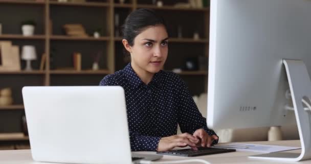 Mujer de raza mixta enfocada en trabajar aprendiendo usando tecnología moderna — Vídeos de Stock