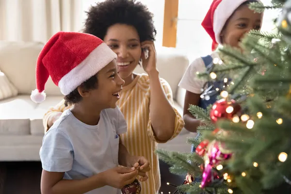 Happy african american family decorating Christmas tree. — Stock Photo, Image