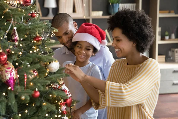 Happy african american parents decorating Christmas tree with son. — Stock Photo, Image