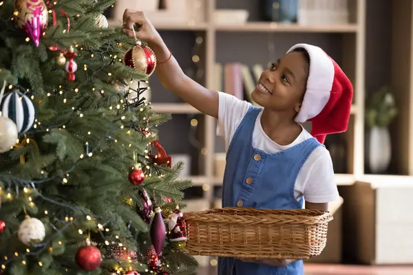 クリスマスツリーを飾る幸せな小さなアフリカ系アメリカ人の女の子. — ストック写真