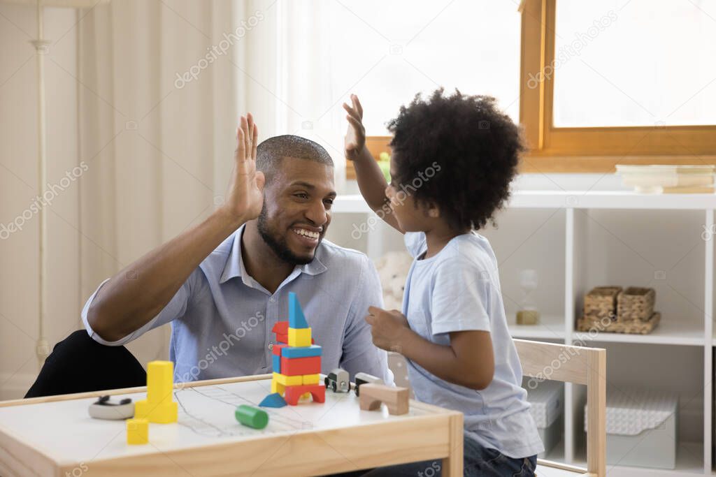 Happy african american family playing toys at home.
