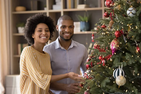 Portrait of smiling african american couple posing near decorated tree. — Stock Photo, Image