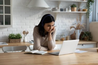 Kulaklıklı Asyalı kız öğrenci Webinar 'ı izliyor.