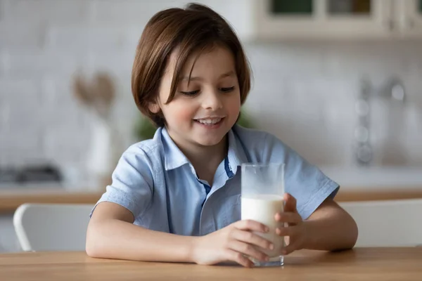 Garçon heureux avec drôle de moustache blanche boire du lait — Photo