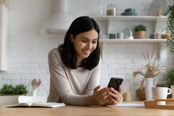 Mujer asiática feliz leyendo mensaje de texto en la pantalla del teléfono móvil — Foto de Stock