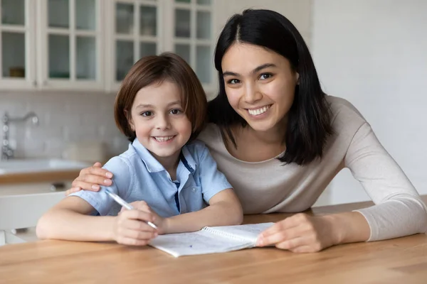 Lycklig mamma och skolpojke son gör läxor — Stockfoto