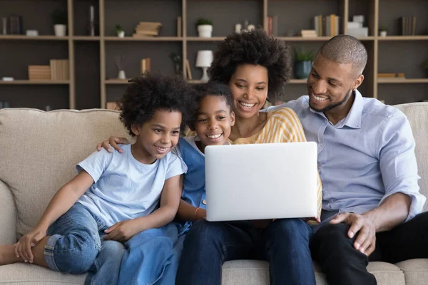 Heureuse famille afro-américaine aimante utilisant un ordinateur à la maison. — Photo