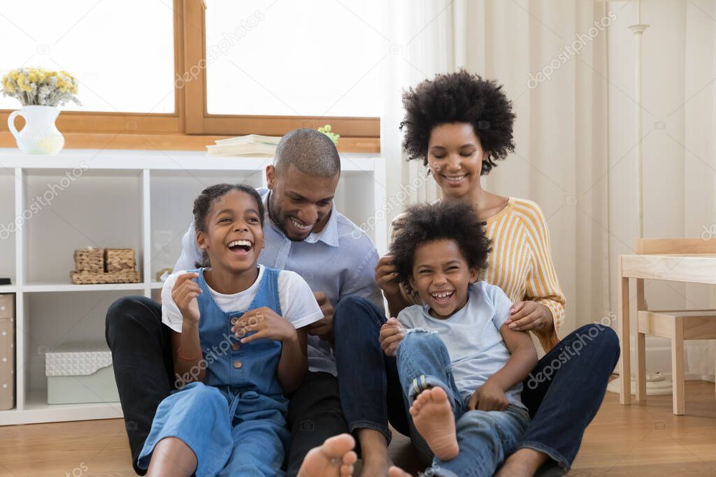 Bonding african american family having fun together at home.