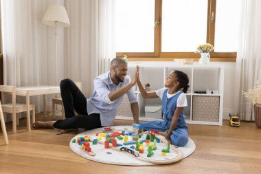 Neşeli Afrikalı Amerikalı baba kızına beşlik çakıyor..