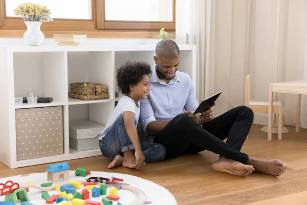 Happy young african american father using tablet with small son. — Stock Photo, Image