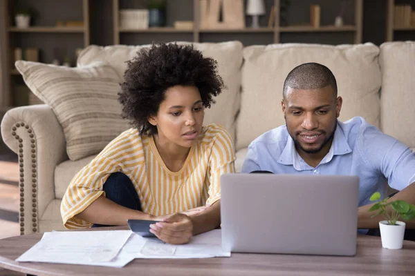 Fokuserad ung afrikansk amerikansk par planerar investering. — Stockfoto