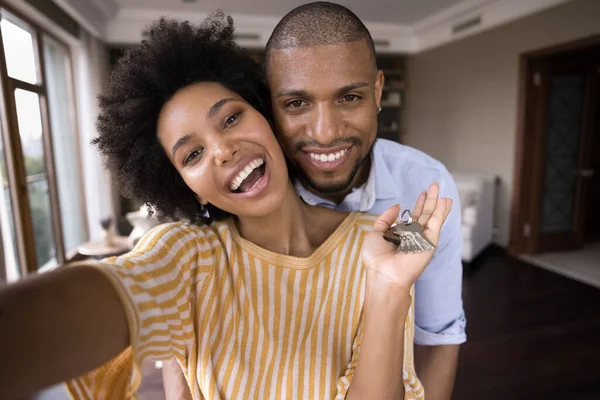Joven pareja afroamericana alegre mostrando las llaves. — Foto de Stock