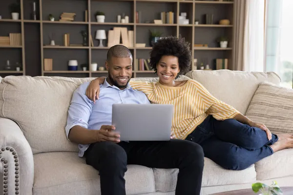 Smiling young mixed race family couple using computer. — Stock Photo, Image