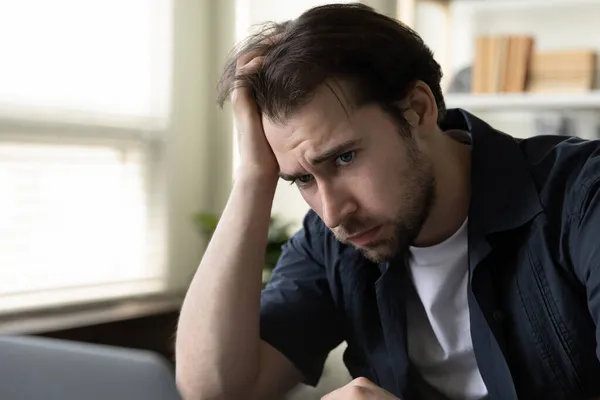 Gestresst ongelukkig jong mannelijk werknemer gevoel uitgeput in het kantoor. — Stockfoto