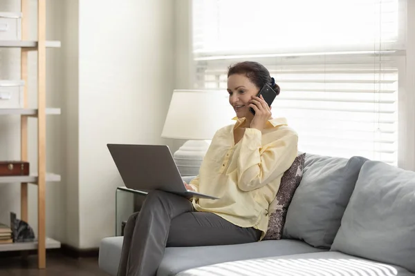 Usmívající se obchodnice středního věku multitasking na domácí kanceláři. — Stock fotografie