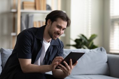 Dijital bilgisayar tableti kullanan mutlu genç adam..