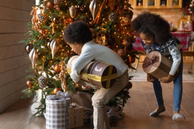 Aşırı neşeli melez çocuklar Noel hediyelerini açmaya hazır.