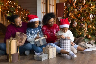 Mutlu çift ırklı aile Noel hediyelerini evde paketler.