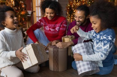 Heyecanlı çift ırklı aile Noel hediyelerini birlikte açıyor.