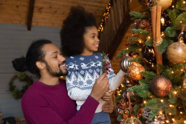 Mutlu çift ırklı baba ve küçük kız köknar ağacı süsledi