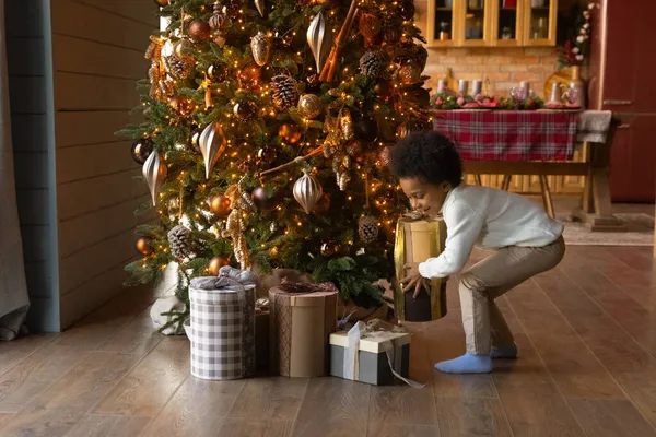 Aufgeregtes kleines Kind packt Weihnachtsgeschenke aus — Stockfoto