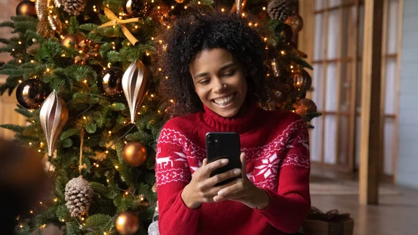 Uśmiechnięta birasowa kobieta ma przyjemne wideo rozmowy na komórkę — Zdjęcie stockowe