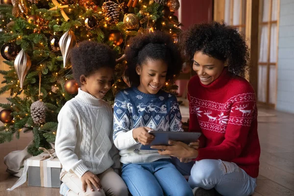 Happy biracial mom and little kids play on tablet — Stock Photo, Image