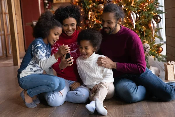 Happy biracial rodina s dětmi používat mobilní telefon doma — Stock fotografie